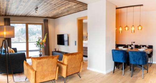 a dining room with a table and blue chairs at Residenz Illyrica Tirol in Westendorf
