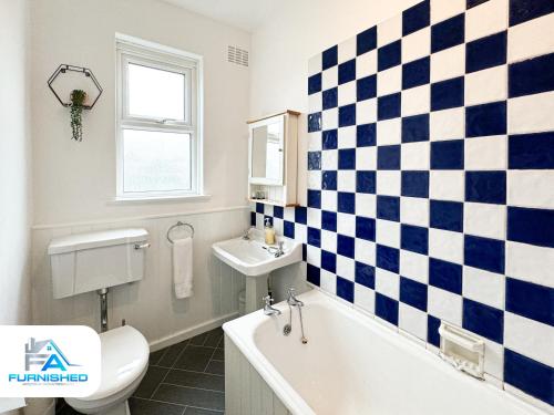 uma casa de banho com azulejos xadrez na parede em Free Parking - Family Stays - Spacious em Harrogate