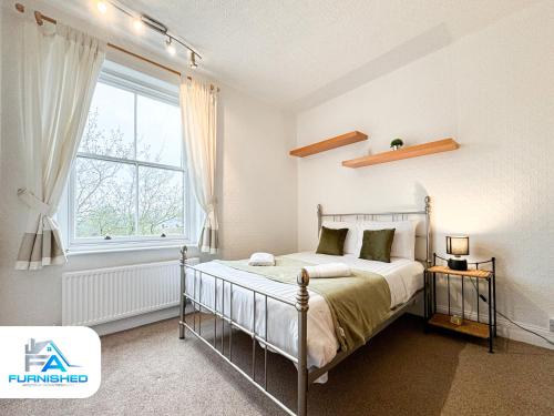 um quarto com uma cama e uma grande janela em Free Parking - Family Stays - Spacious em Harrogate