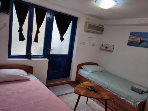 um quarto com uma cama, uma mesa e uma janela em Bay Mola Home em Kotor