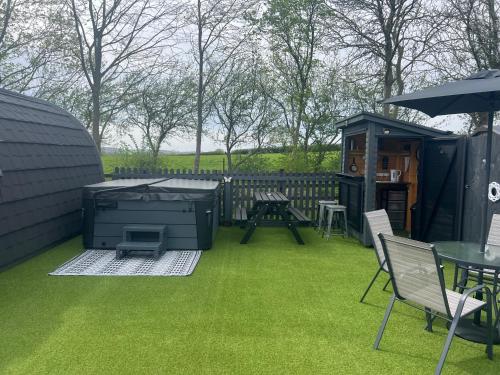 a backyard with a grill and a table and chairs at Little Bunny Retreat in Bradmore
