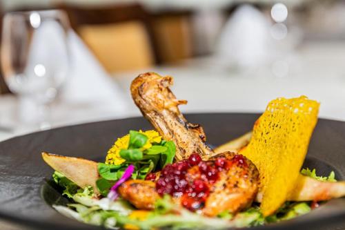 a black plate with food on a table at Kontakt Wellness Hotel in Tatranská Lomnica