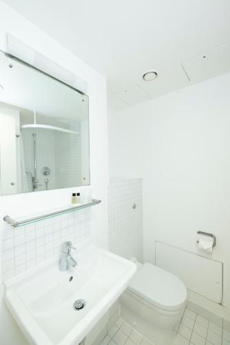 a white bathroom with a sink and a toilet at Stephen Hawking Building Gonville and Caius College in Cambridge