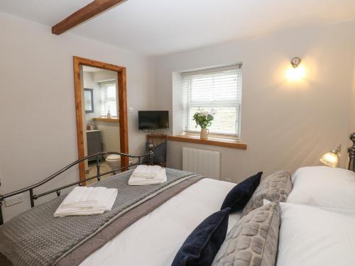 a bedroom with two beds and a mirror at Larl Cottage in Barnard Castle