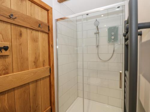a bathroom with a shower with a glass door at Larl Cottage in Barnard Castle