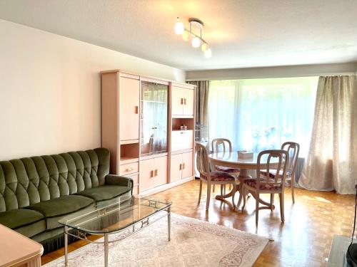 - un salon avec un canapé vert et une table dans l'établissement Flat at border suisse, à Saint-Louis