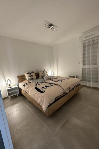 une chambre avec un grand lit dans une pièce dans l'établissement T2 Appartement Sunset Lodge à 250 m de la mer, 3 couchages, à Narbonne-Plage