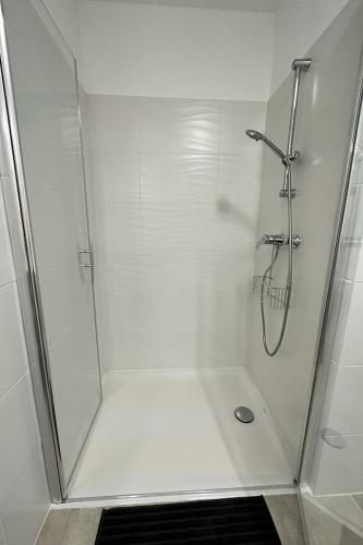 une douche avec une porte vitrée et une douche à l'italienne dans l'établissement T2 Appartement Sunset Lodge à 250 m de la mer, 3 couchages, à Narbonne-Plage