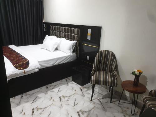 a hotel room with a bed and a chair at Downunder suites in Gwarinpa