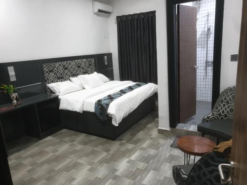 a bedroom with a large bed and a chair at Downunder suites in Gwarinpa