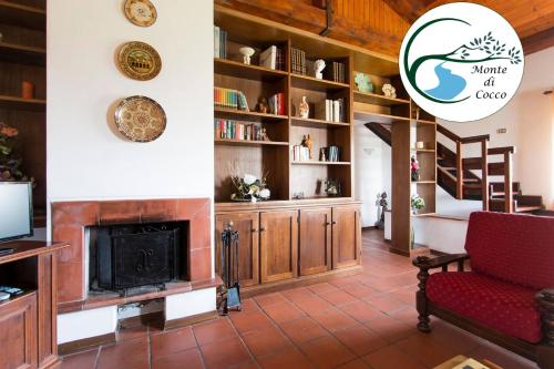 a living room with a fireplace and bookshelves at Villa del Monte di Cocco in Massarosa