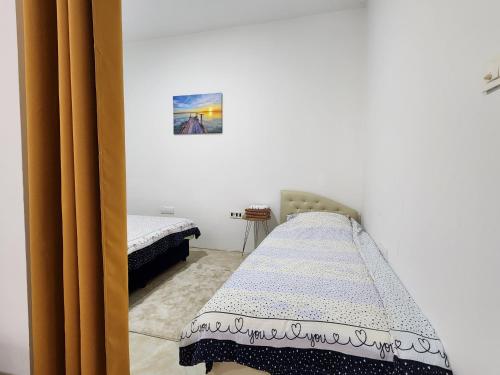a bedroom with two beds and a painting on the wall at Apartman MAJ in Bijelo Polje