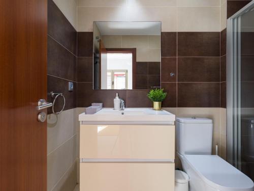 a bathroom with a sink and a toilet and a mirror at Montevideo By CanariasGetaway in Guanarteme
