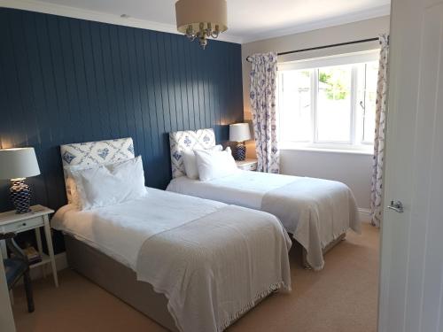 a bedroom with two beds and a window at Baskerville House in Clyro