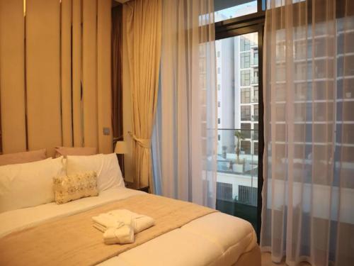Cama en habitación con ventana grande en Business Bay Stylish Apartment In Dubai en Dubái