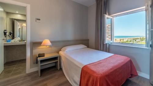 een hotelkamer met een bed en een raam bij Pato Rojo in Punta Umbría
