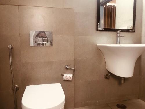 ein Badezimmer mit einem weißen WC und einem Waschbecken in der Unterkunft Tulip Grand in Jaipur
