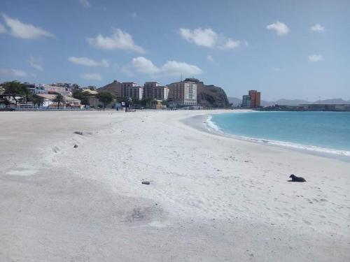 a sandy beach with buildings in the background at Flat City Center Mindelo in Mindelo