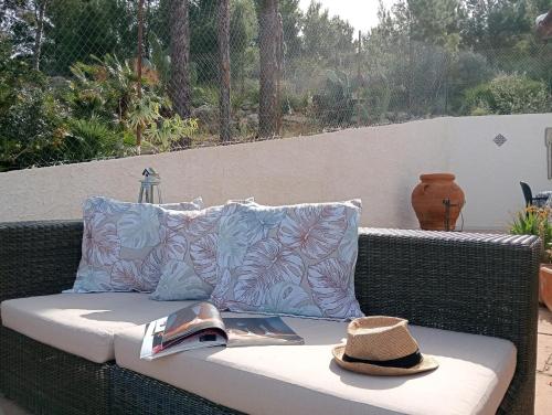 a hat and a book sitting on a wicker bench at LE SORELLE entire villa sea view in Scopello