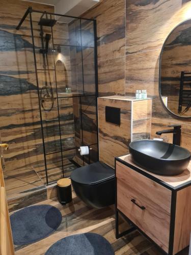 a bathroom with a black sink and a mirror at Konie2 Pokoje Gościnne in Wetlina