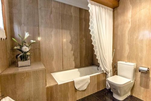 a bathroom with a toilet and a bath tub at Picturesque Costa Brava Countryside Villa in Les Planes d'Hostoles