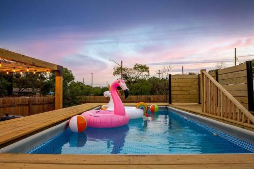 a swimming pool with a pink flamingo float in the water at Pool-MovieTheater KING BED & 5 minutes to Alamodome in San Antonio