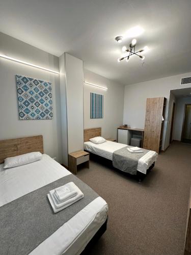 Habitación de hotel con 2 camas y escritorio en PORT INN Hotel en Astaná