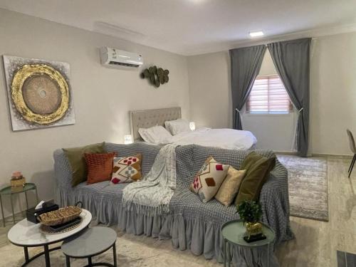 1 dormitorio con 1 cama y 1 sofá con almohadas en استديو مميز وانيق, en Al Khobar