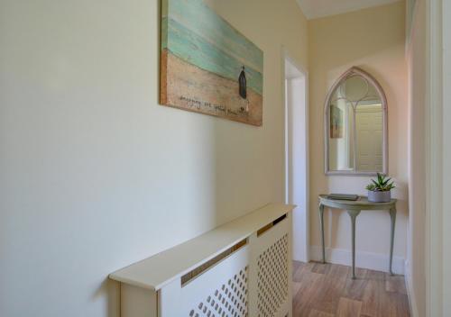 a hallway with a table and a picture on the wall at Sea Peeps in Hunstanton