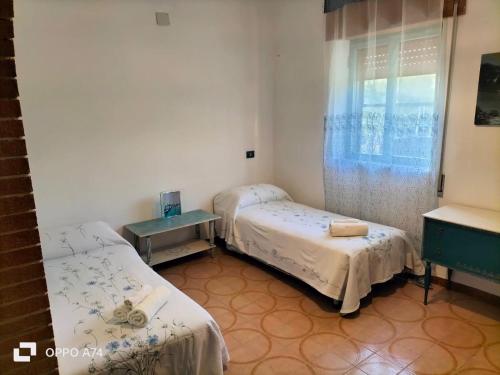 um quarto de hospital com duas camas e uma janela em Casa vacanze sa Cresiedda em Iglesias