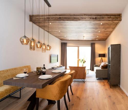a dining room and living room with a table and chairs at Residenz Illyrica Tirol in Westendorf