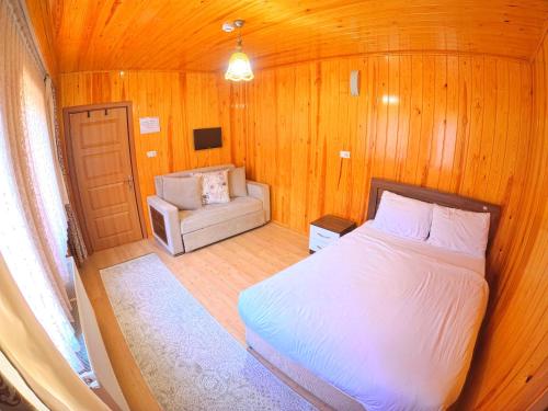 ein Schlafzimmer mit einem Bett und einem Sofa in einem Zimmer in der Unterkunft UZUNGÖL ADİLOGLU SUIT in Uzungöl