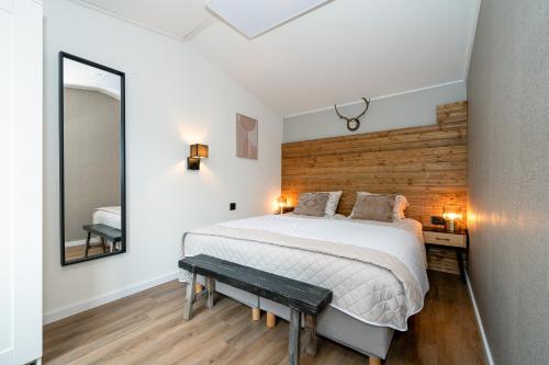 a bedroom with a large bed and a mirror at Hotel chique chalet met zicht over de weilanden op de Veluwe in Epe