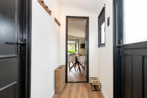 a hallway with a door leading to a dining room at Hotel chique chalet met zicht over de weilanden op de Veluwe in Epe