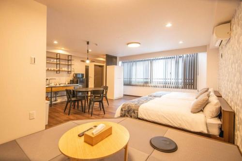 a hotel room with a bed and a table at 浅草禅心居201室 浅草駅徒歩15分 2024年4月ニューオープン 43平米丸貸し切り ダブルベット2台と畳敷き布団2組 家庭式用品設備完備 in Tokyo