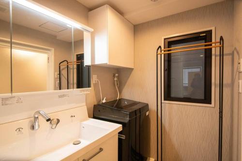 a small bathroom with a sink and a stove at 浅草禅心居201室 浅草駅徒歩15分 2024年4月ニューオープン 43平米丸貸し切り ダブルベット2台と畳敷き布団2組 家庭式用品設備完備 in Tokyo