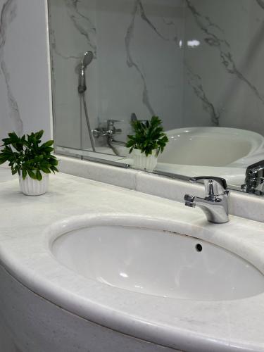 a bathroom sink with a faucet and a mirror at PORT INN Hotel in Astana