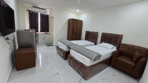 een slaapkamer met 2 bedden, een bank en een televisie bij Single Suite room in Hyderabad