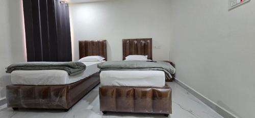 twee bedden in een kamer met bij Single Suite room in Hyderabad