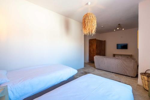 a bedroom with two beds and a chandelier at CasaLyma Ayvalık in Ayvalık