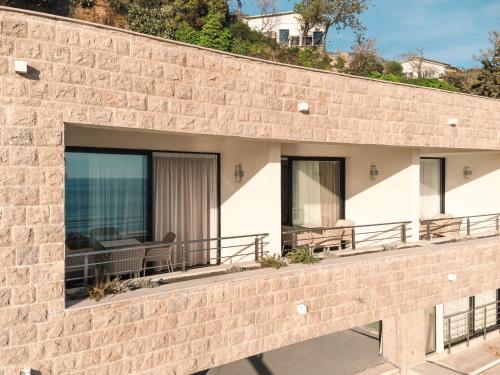 a brick building with a balcony with chairs on it at Miramar in Ulcinj