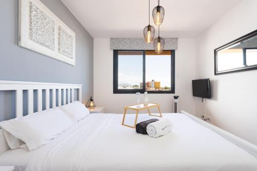 Un dormitorio blanco con una cama y una mesa. en Casa Julia, en Playa Paraiso