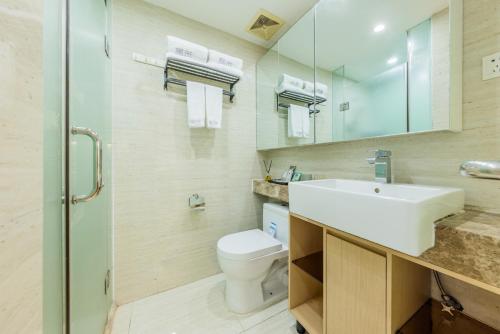 y baño con lavabo, aseo y espejo. en Roomme私享家东山口地铁站公寓, en Guangzhou