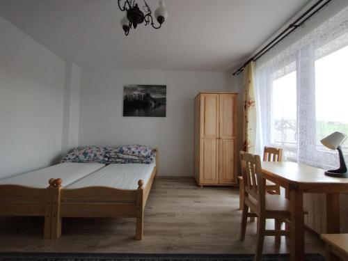 a bedroom with a bed and a table and a desk at Trzech Koron 16 in Sromowce Wyżne