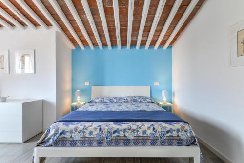 a bedroom with a bed and a blue wall at Tosca in Capoliveri