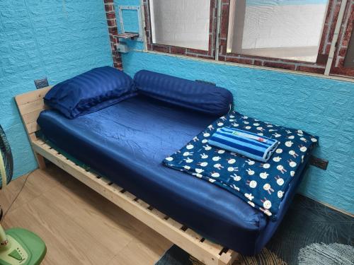 a bed in a room with a blue wall at 206 Quiet and Cozy Apartment in Bangkok