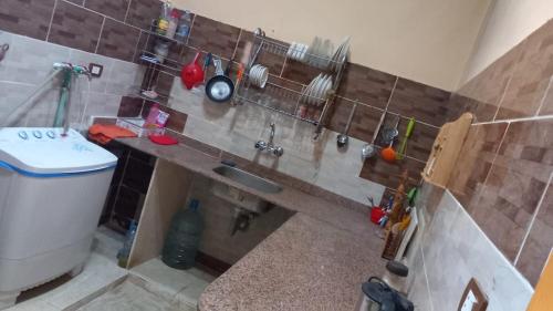- une cuisine avec un évier et un comptoir avec des ustensiles dans l'établissement فيلا حبيبه, à ‘Izbat Ţanāţī