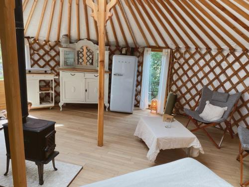 a room with a refrigerator and a table in a yurt at Ons Yurt Huisje in het Bos in Hollandsche Rading