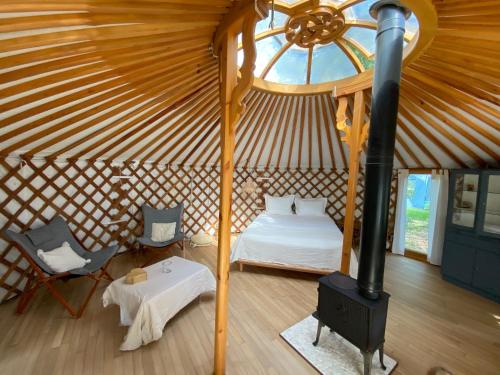a bedroom in a yurt with a bed and a stove at Ons Yurt Huisje in het Bos in Hollandsche Rading