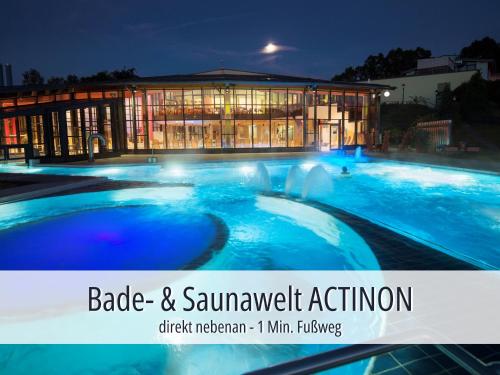 a large building with a swimming pool at night at Hotel Am Kurhaus mit erstem Ayurveda Center Sachsens - direkt am Gesundheitsbad ACTINON & Kurpark in Bad Schlema